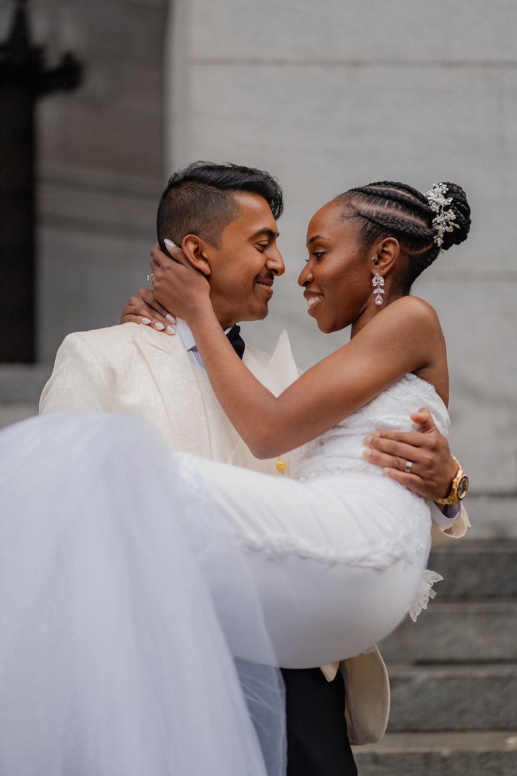 Romantic wedding portrait of couple sharing tender moment on stone steps.