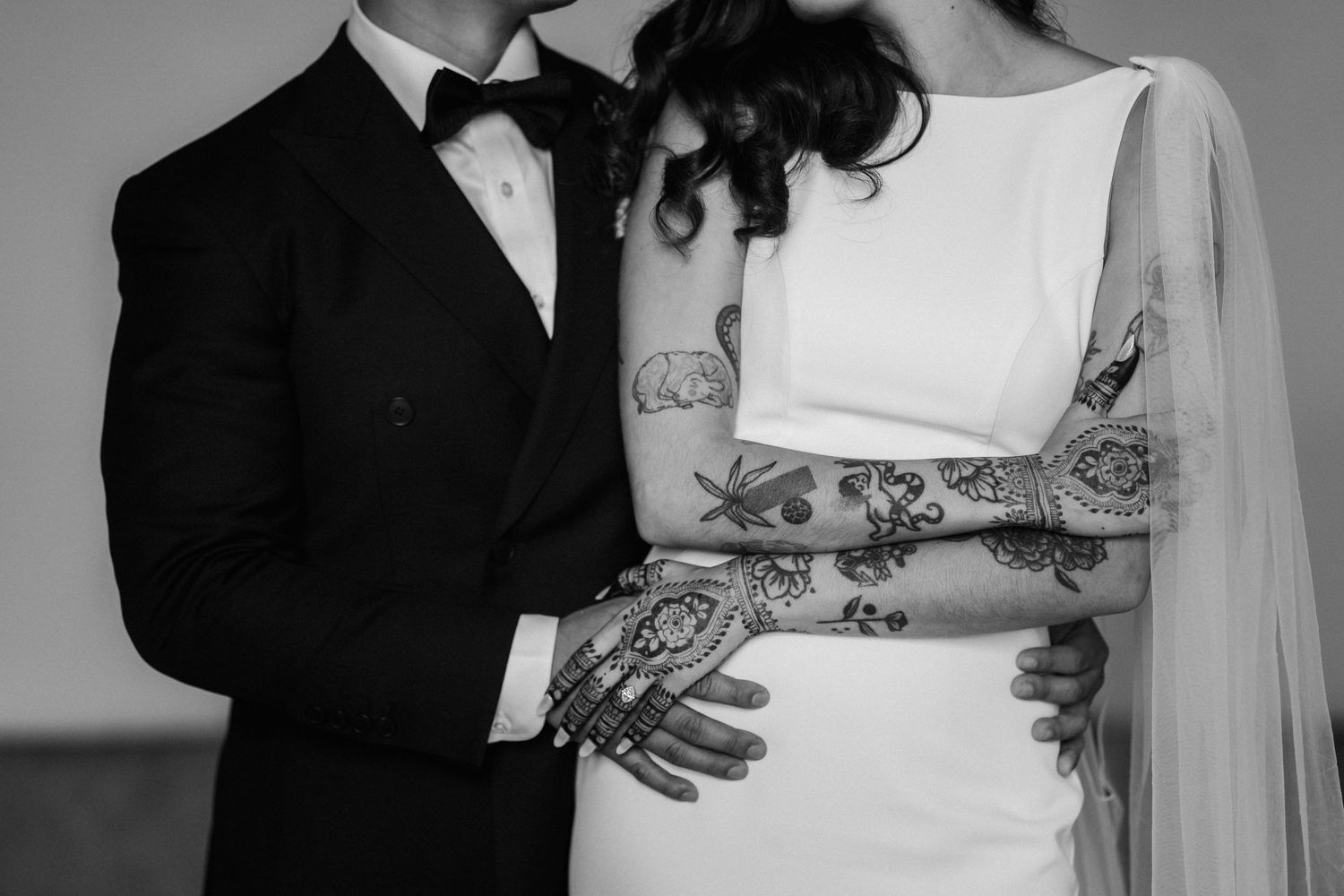 Black and white portrait capturing tender moments between a couple in formal wedding attire.