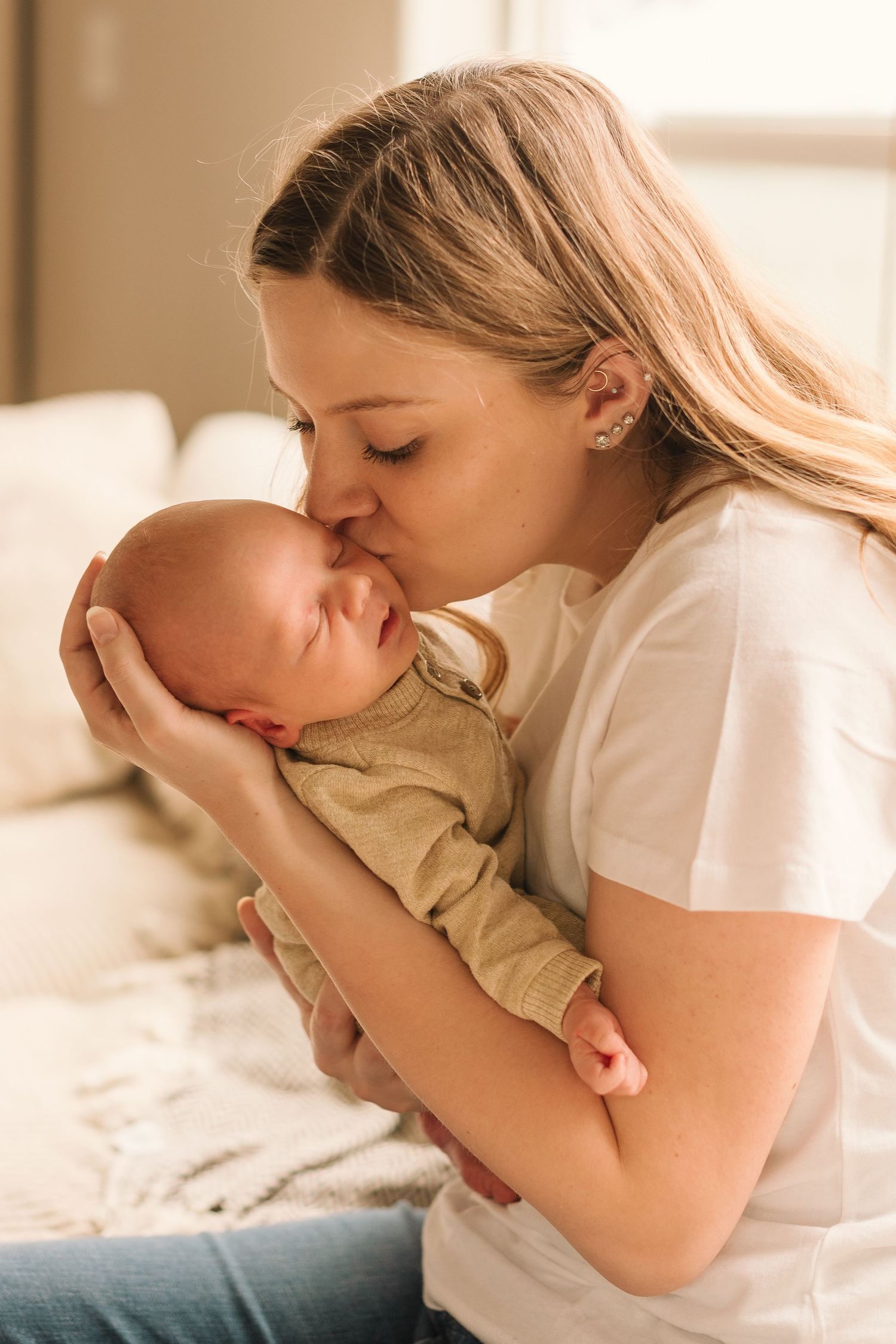 Sweet lifestyle photos showing tender moments between parent and baby in soft natural light.