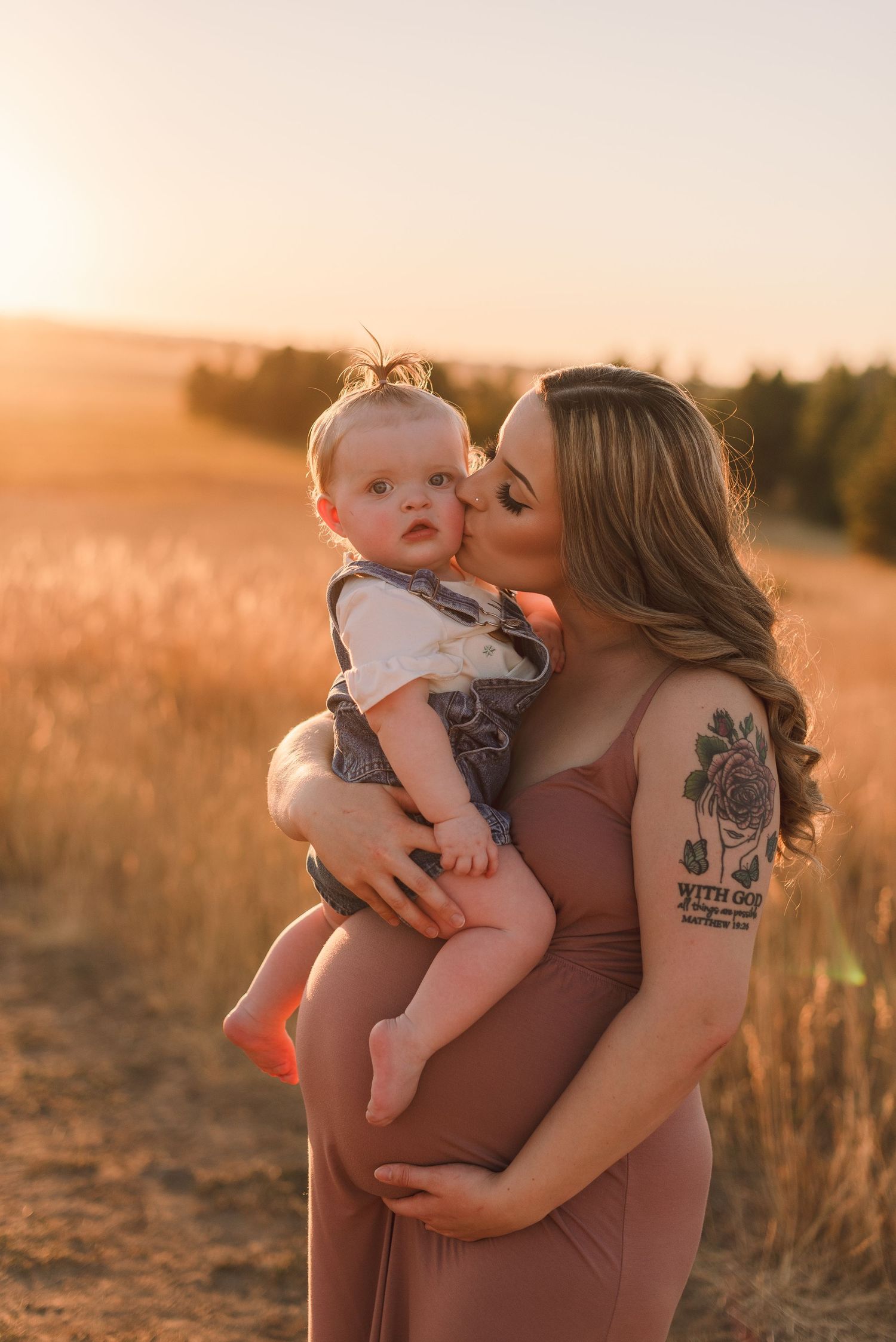 Maternity photo session in Spokane, Washington at golden hour in a grassy countryside field.