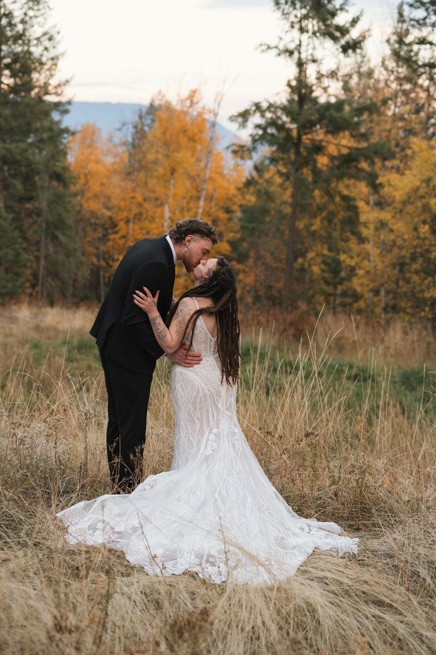 A romantic wedding couple portrait with autumn trees and Idaho mountains in the background. Wedding/ Elopement photography.