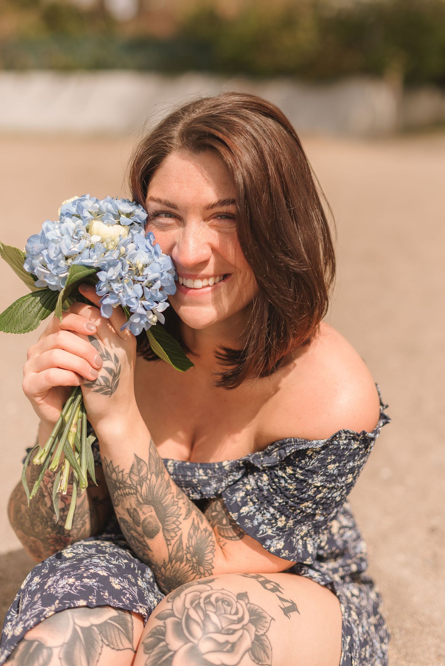 A series of outdoor beach photos showing a person in a floral dress holding blue hydrangea flowers.