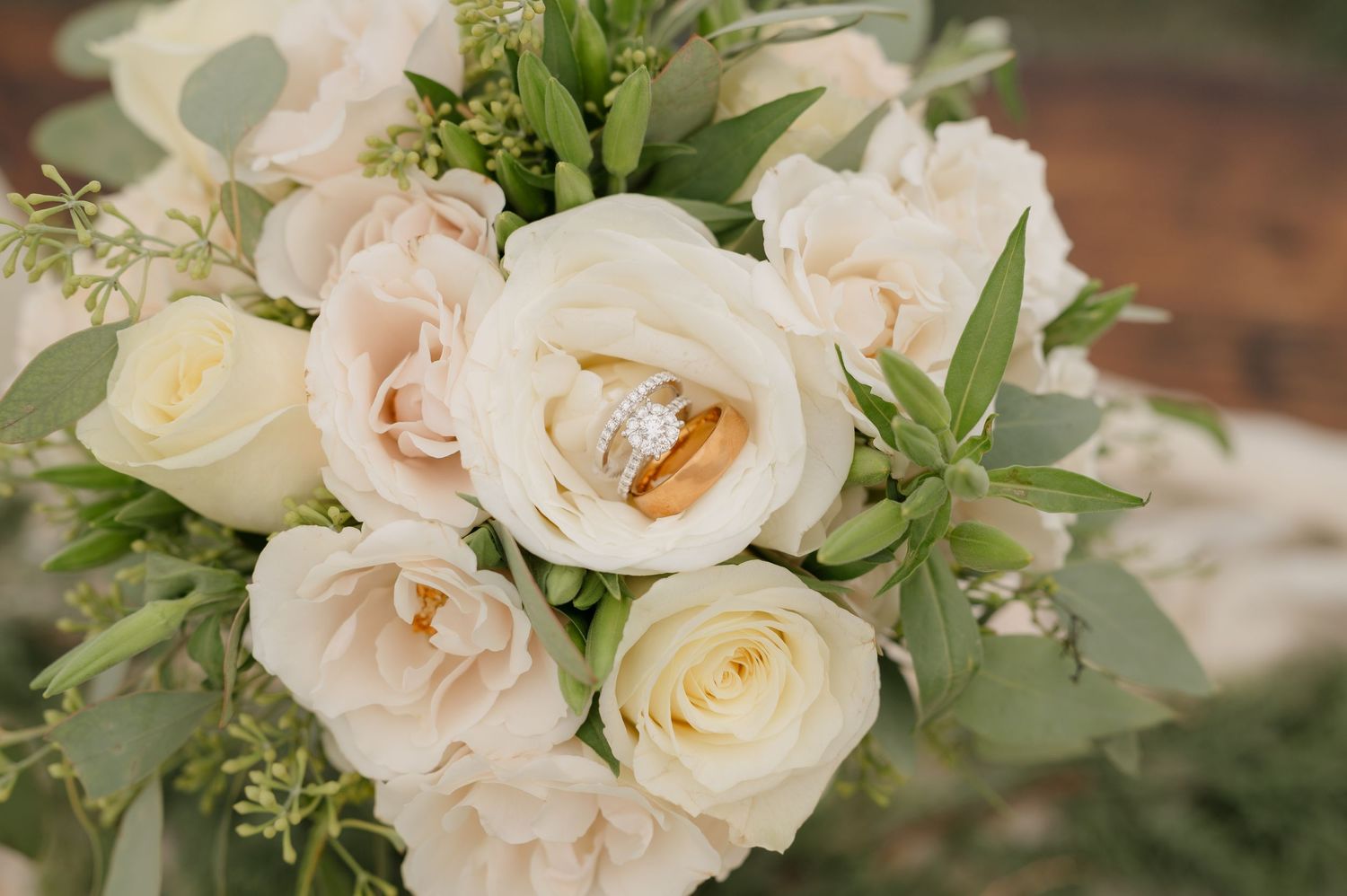 Elegant cream and blush roses with delicate greenery arranged in a romantic wedding floral design.