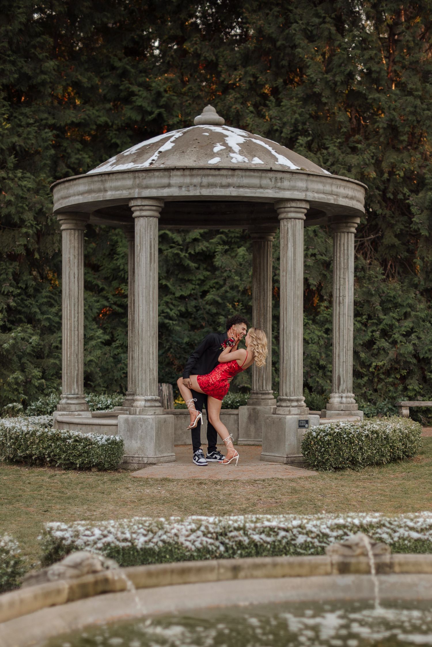 Romantic sequence under a stone gazebo in a garden setting.