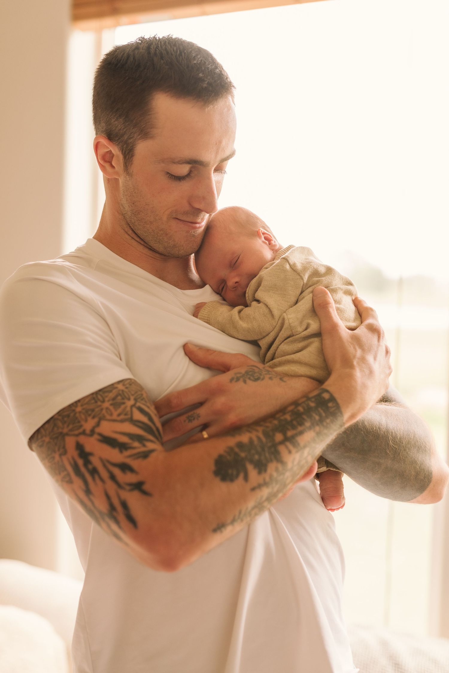 A series of tender moments between parent and newborn in soft natural light, showing gentle embraces and kisses.