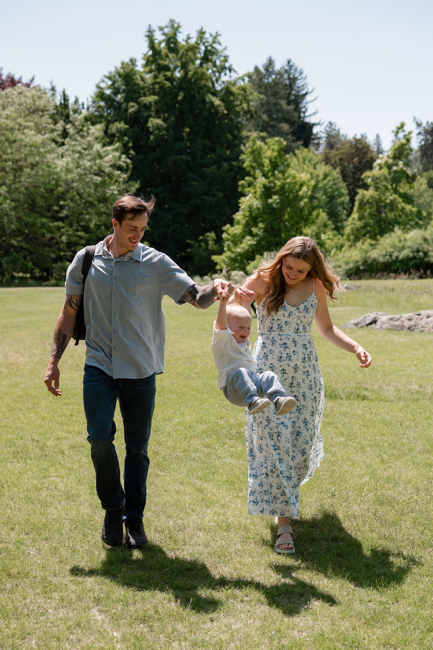 A couple dancing together joyfully in a sunny grassy field on a summer day.