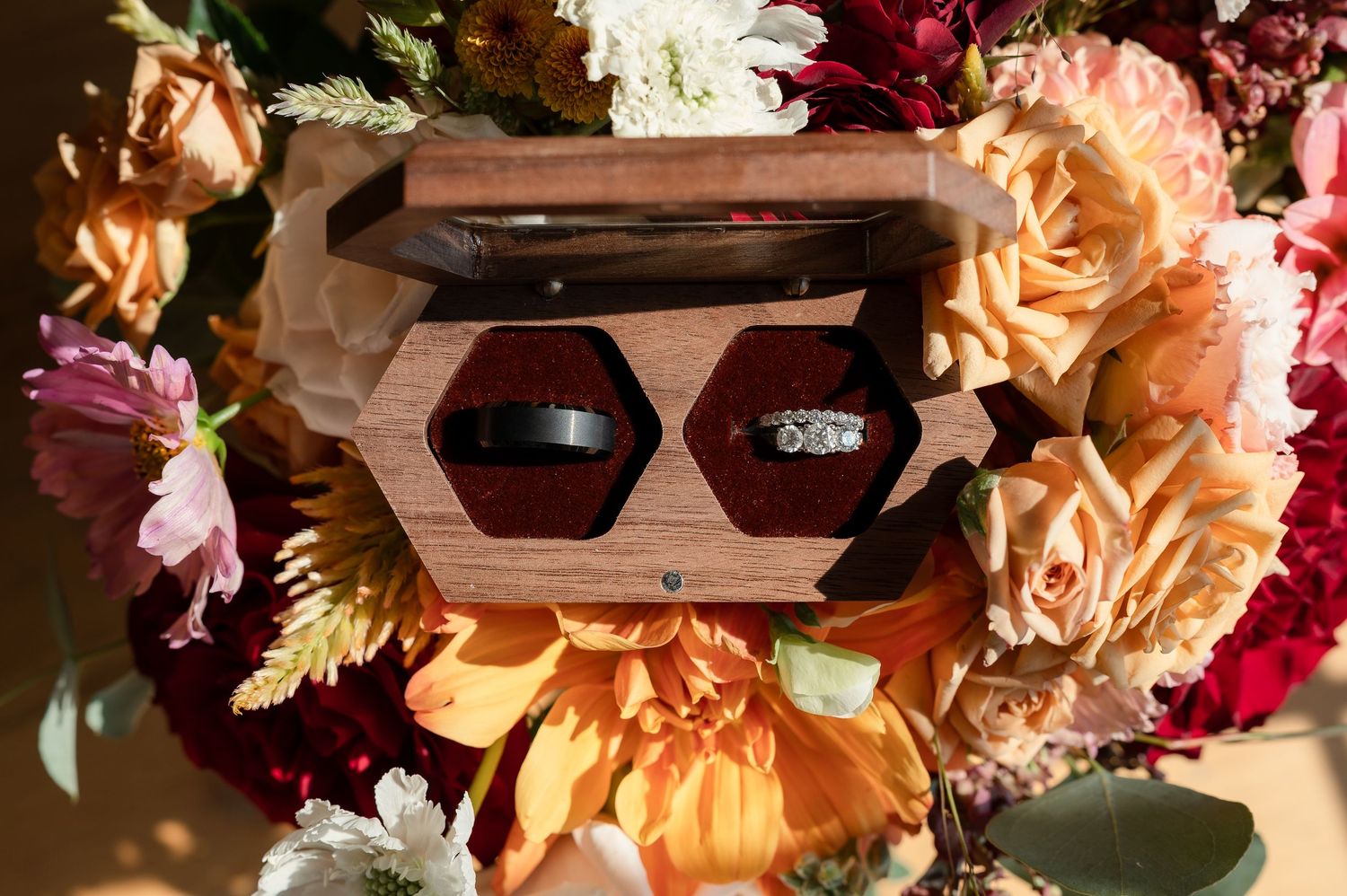 Rustic wedding decorations featuring peach and burgundy floral arrangements with sunflowers and roses.