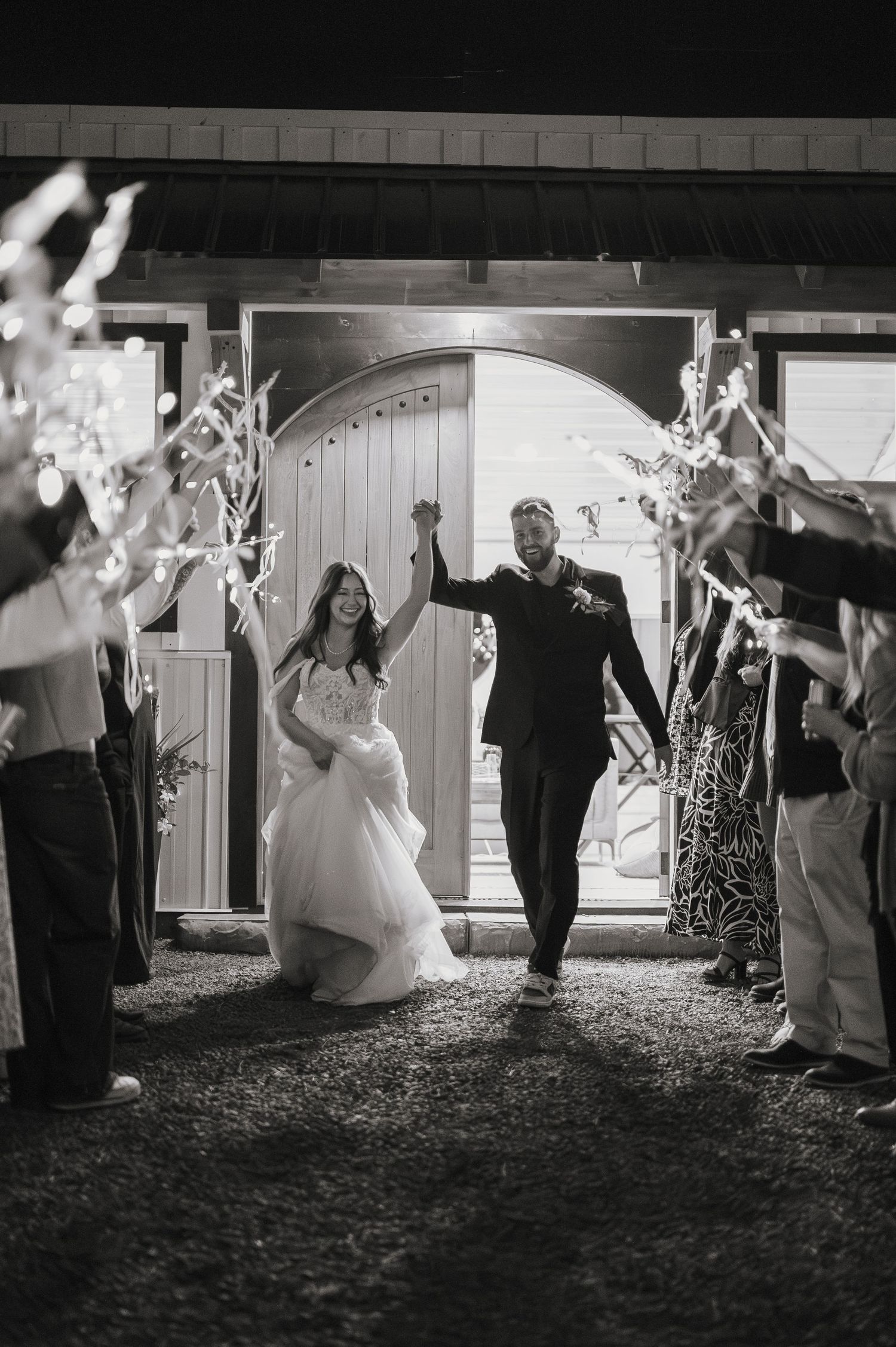 Black and white wedding sparkler exit sequence showing newlyweds walking through glowing sparklers held by guests in Spokane, Washington.