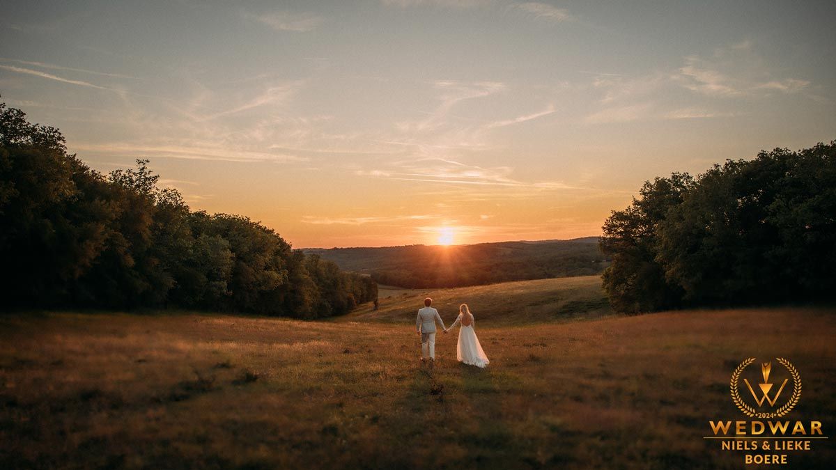 zonsondergang in frankrijk met bruidspaar die van de camera weglopen