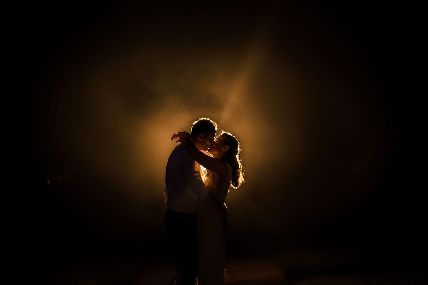 foto van bruidspaar met een oranje licht en mist