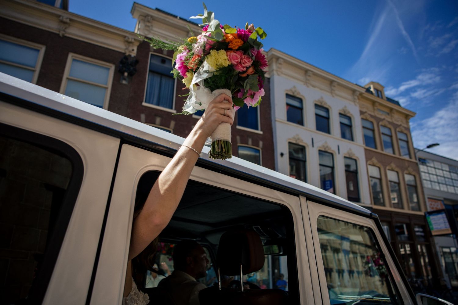 bloemen uit een auto van een bruid