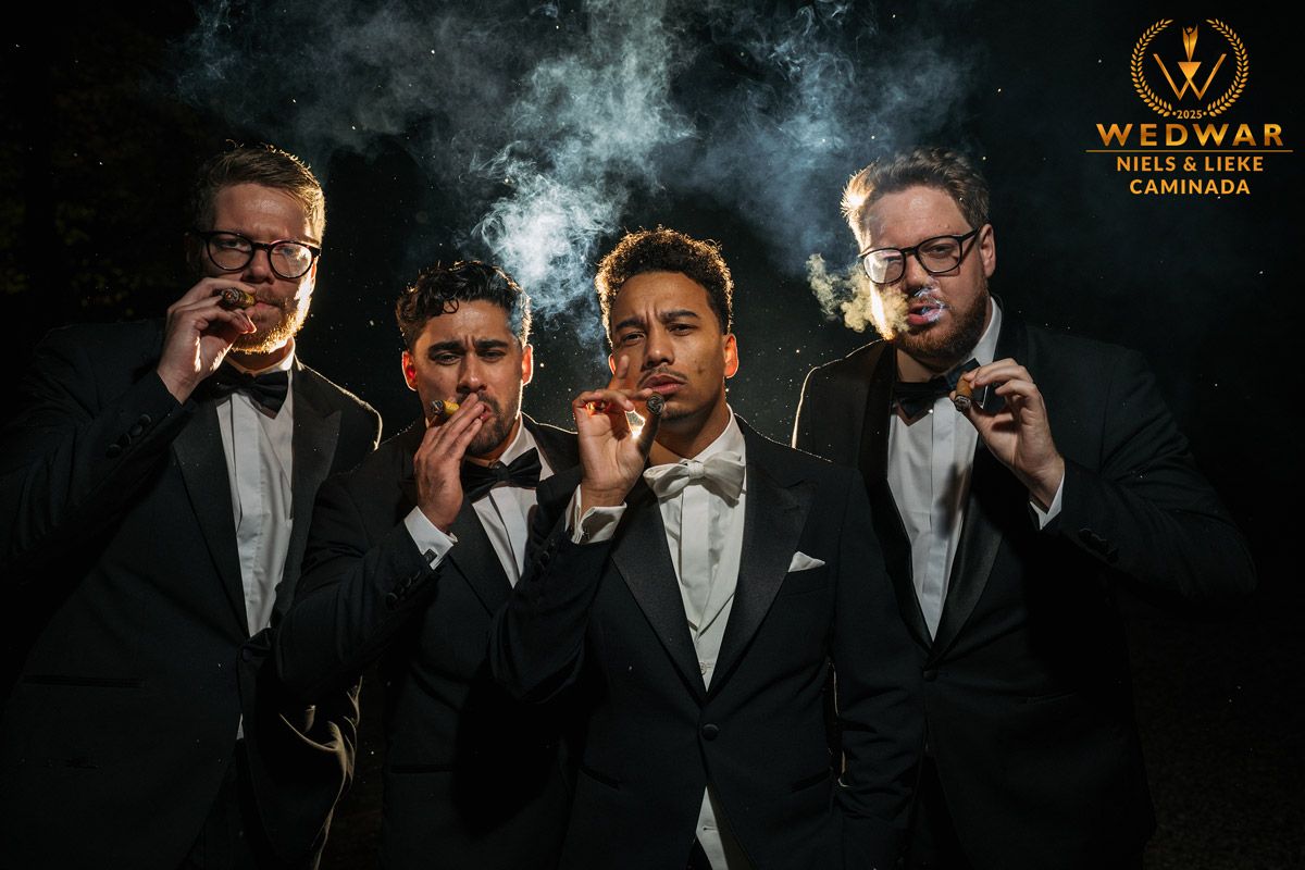 bruidegom en best man roken een sigaar en kijken in de camera wedwar winnende foto