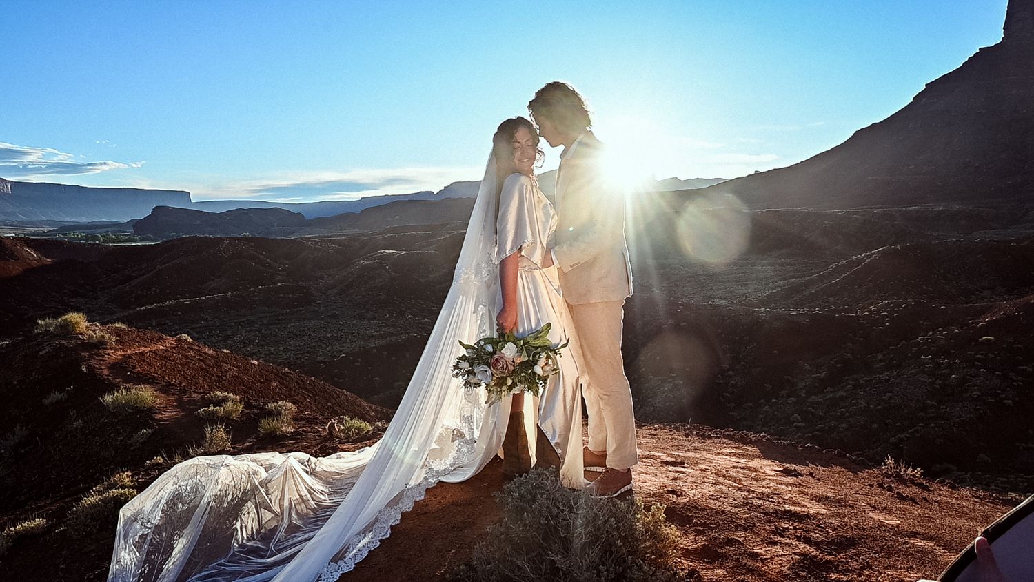 couple exchanging vows at sunrise in an elopement in Moab, Utah, elopement photography, bride and groom, tender moment, bridal veil,