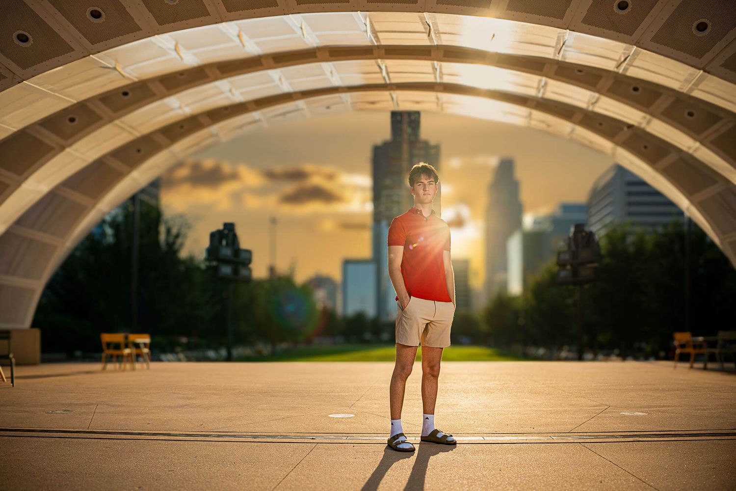A person stands in an illuminated tunnel with arched ceiling and recessed lighting creating a dramatic perspective.