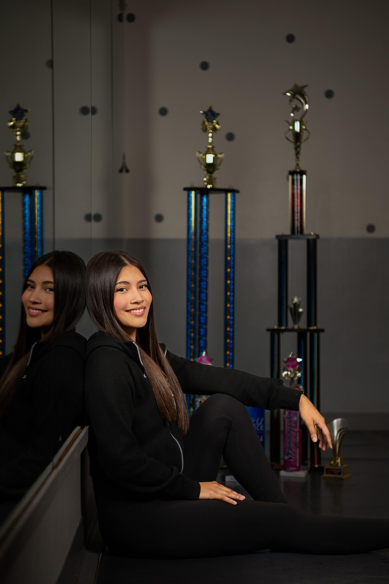 Five sequential photos show someone posing with trophies in a dark room with blue lighting and star decorations.
