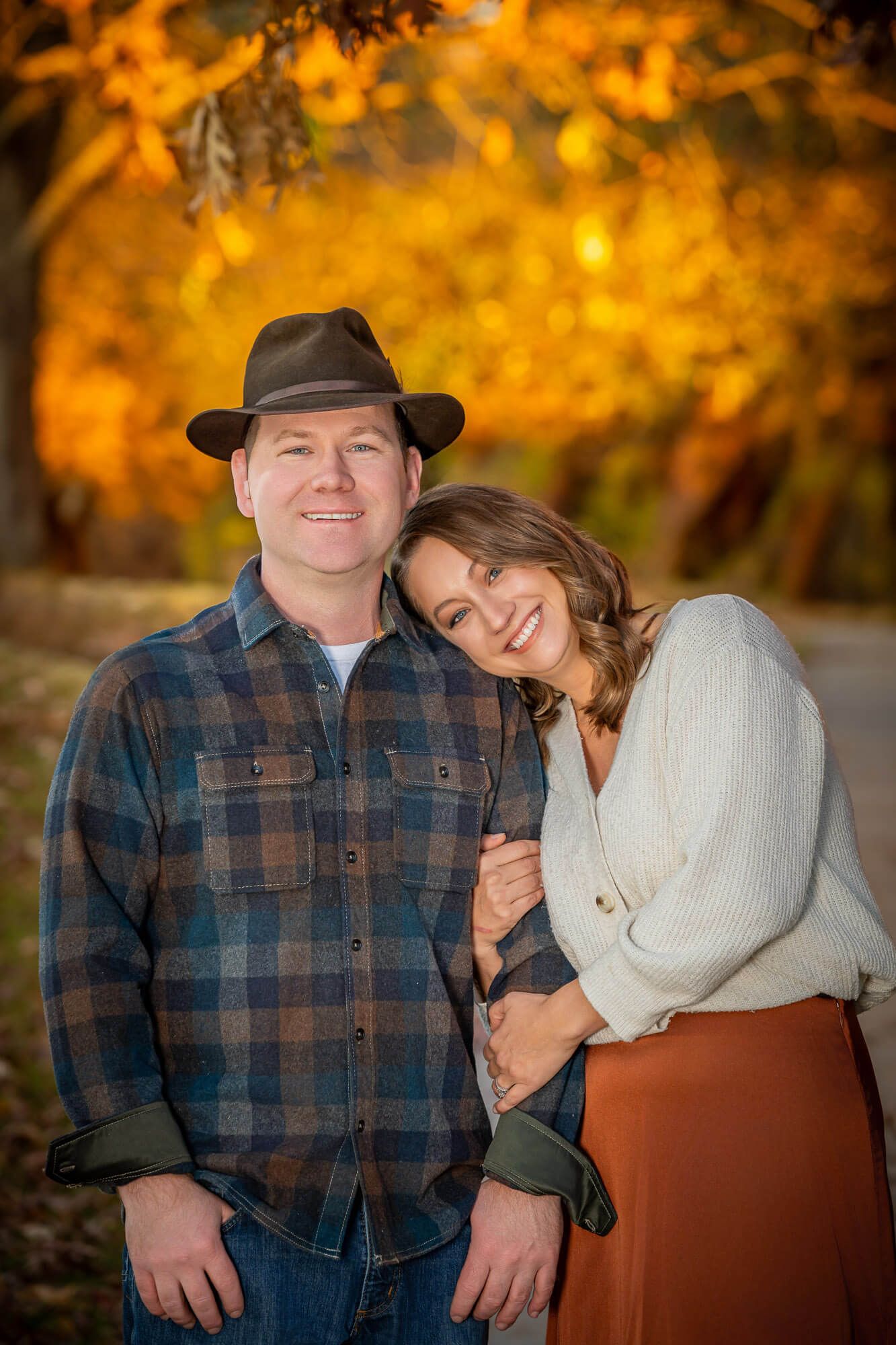 A couple shares tender moments with golden autumn foliage during an outdoor photo session at OPPD Arboretum.