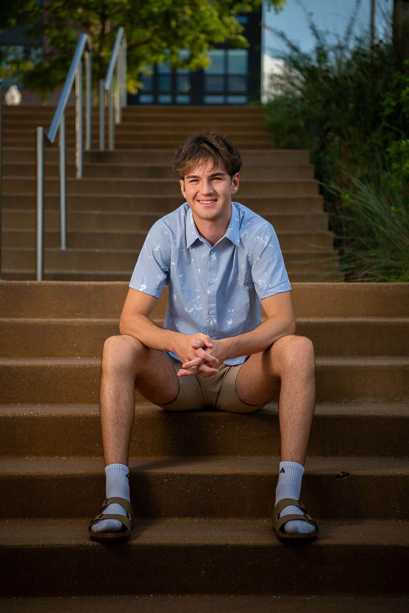 A person in a light blue shirt sits on concrete steps in a series of four similar poses.