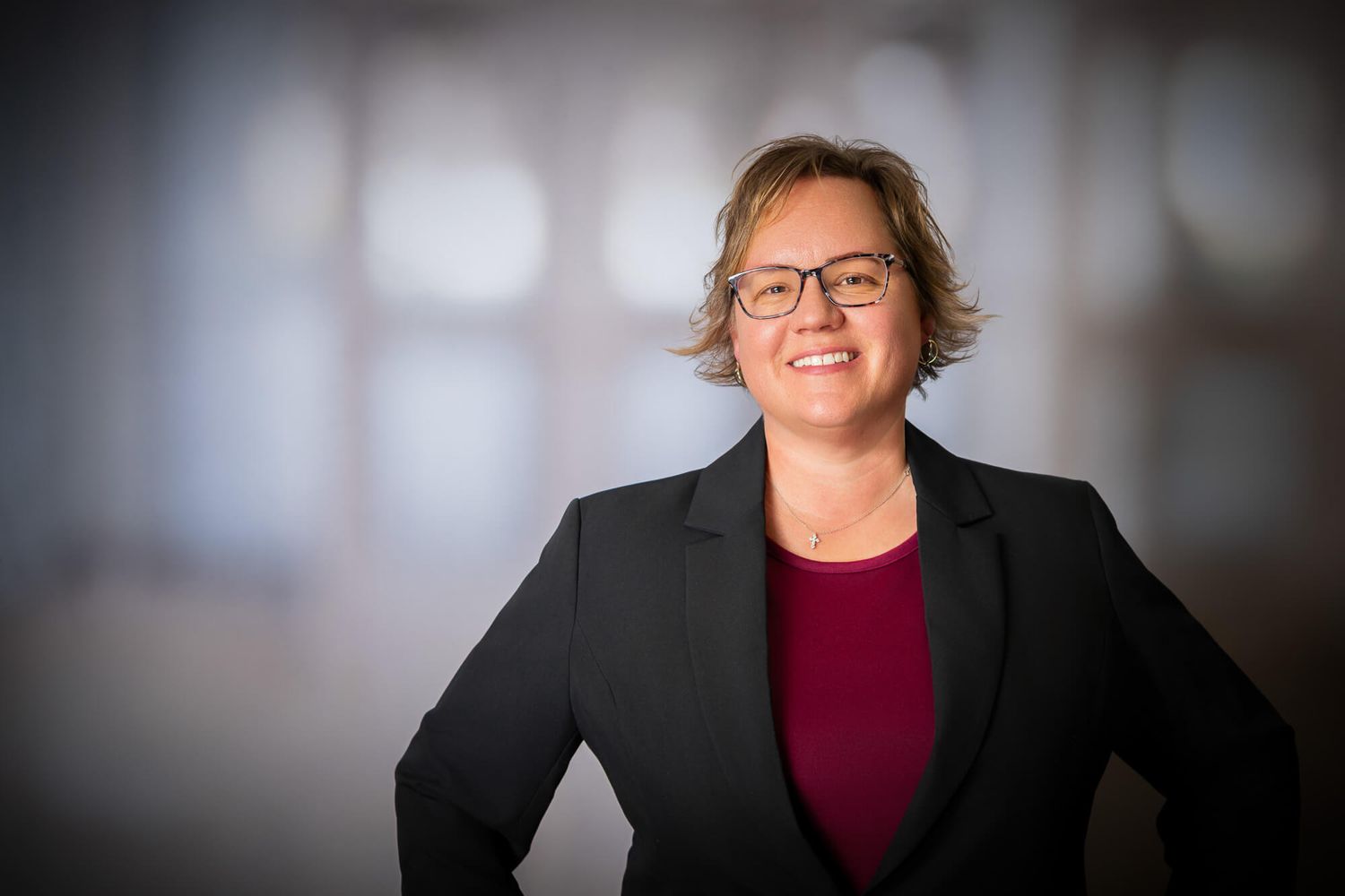 Corporate portraits of two professionals in business attire against dark background.