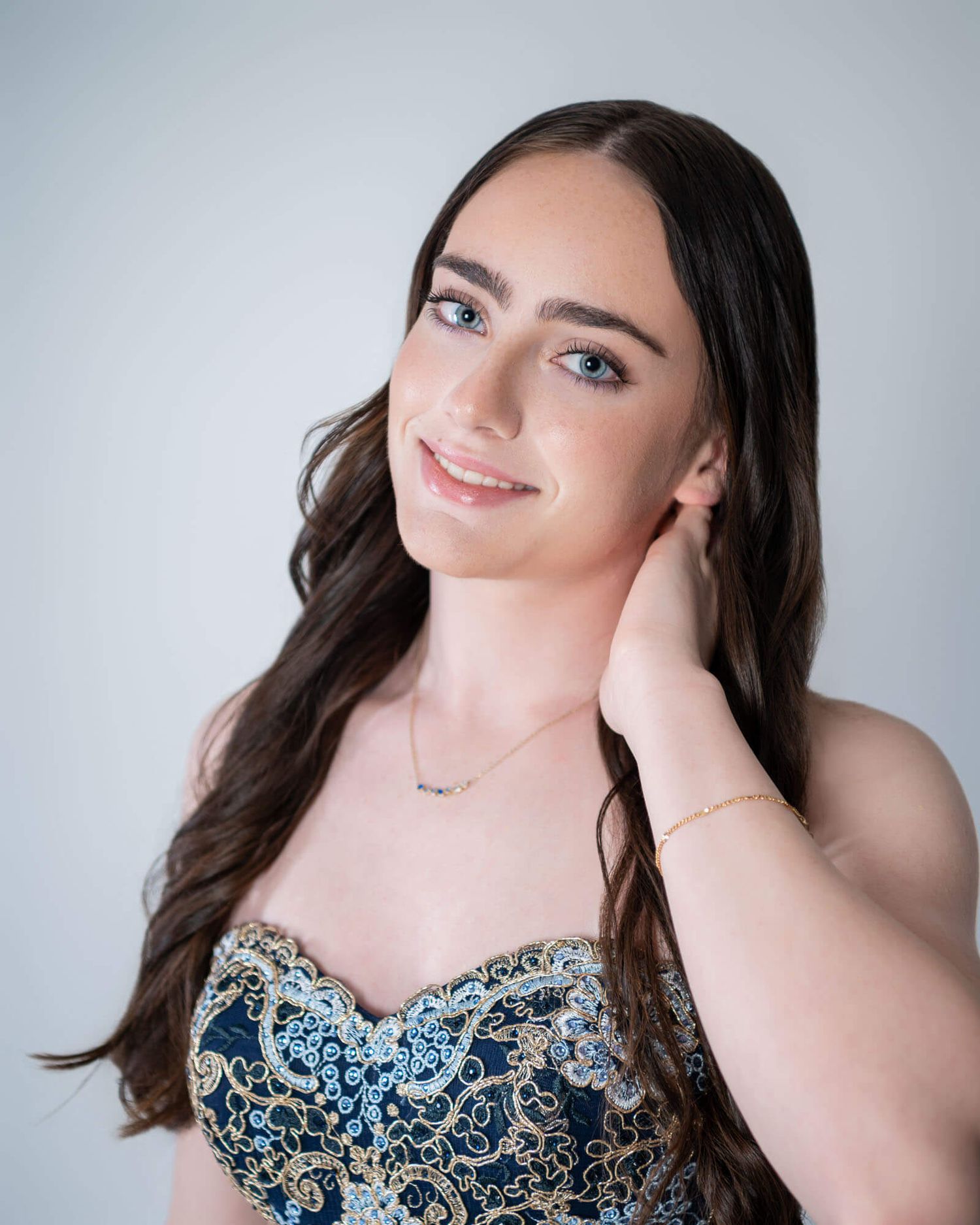 A woman in a floral print dress poses elegantly against a light gray background in a series of glamour shots.
