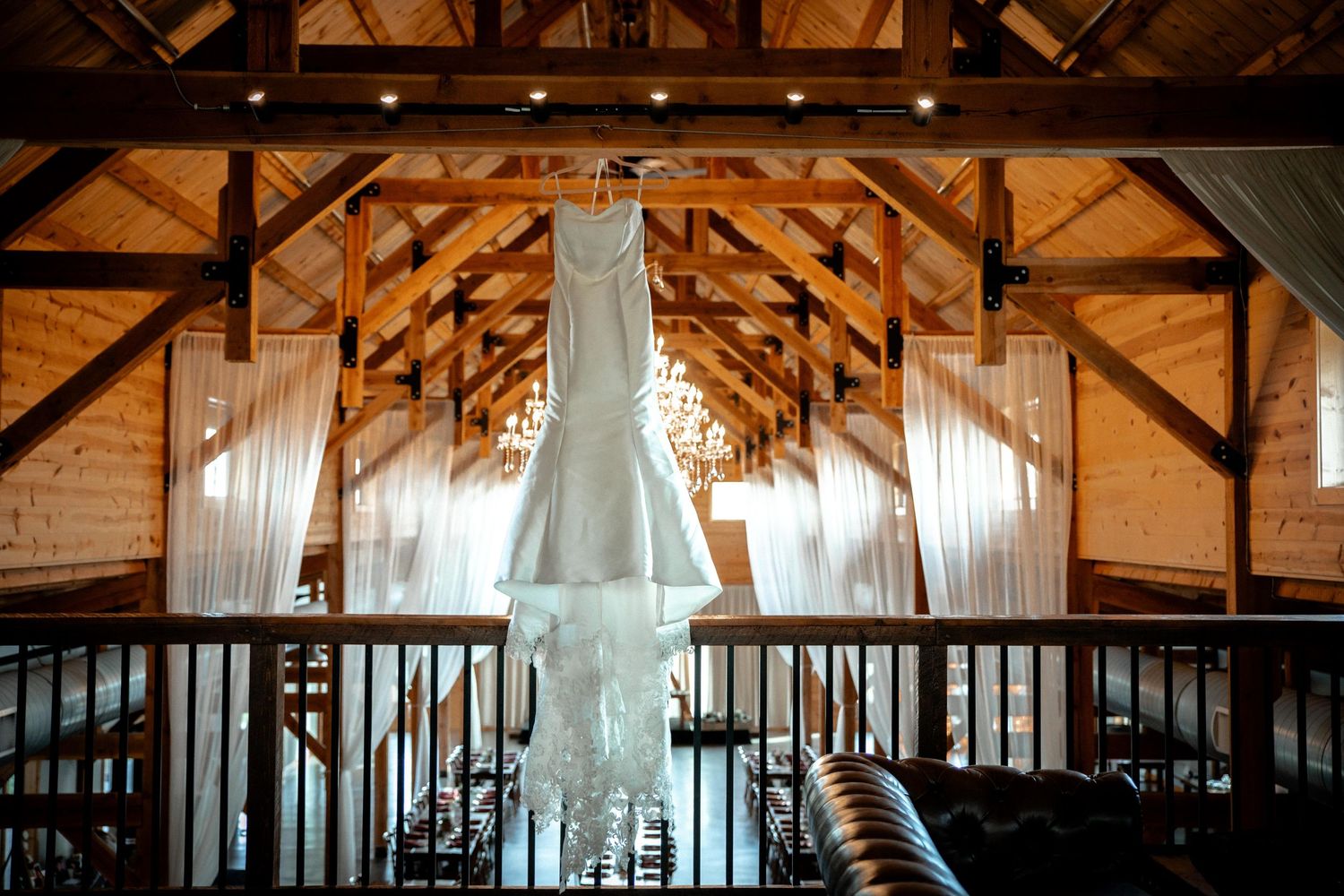 Elegant rustic barn wedding venue with exposed wooden beams and white drapes. Photographer in Sioux Falls, SD