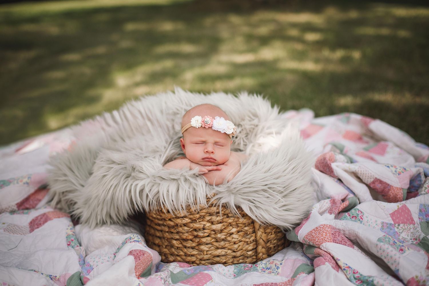 Infant sleeping in wicker basket with soft fur lining and floral accessories.