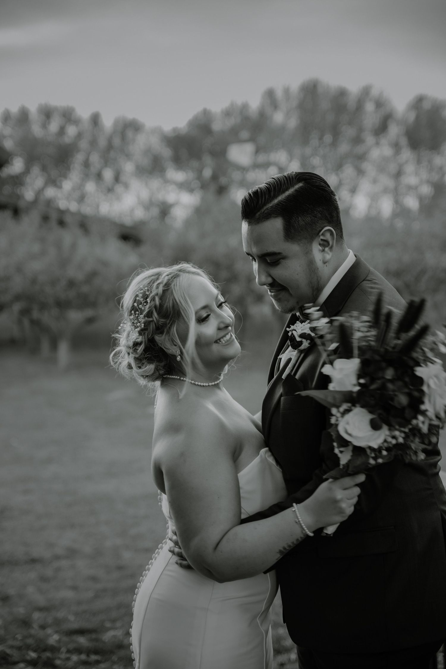 Black and white romantic portrait with burgundy floral bouquet.