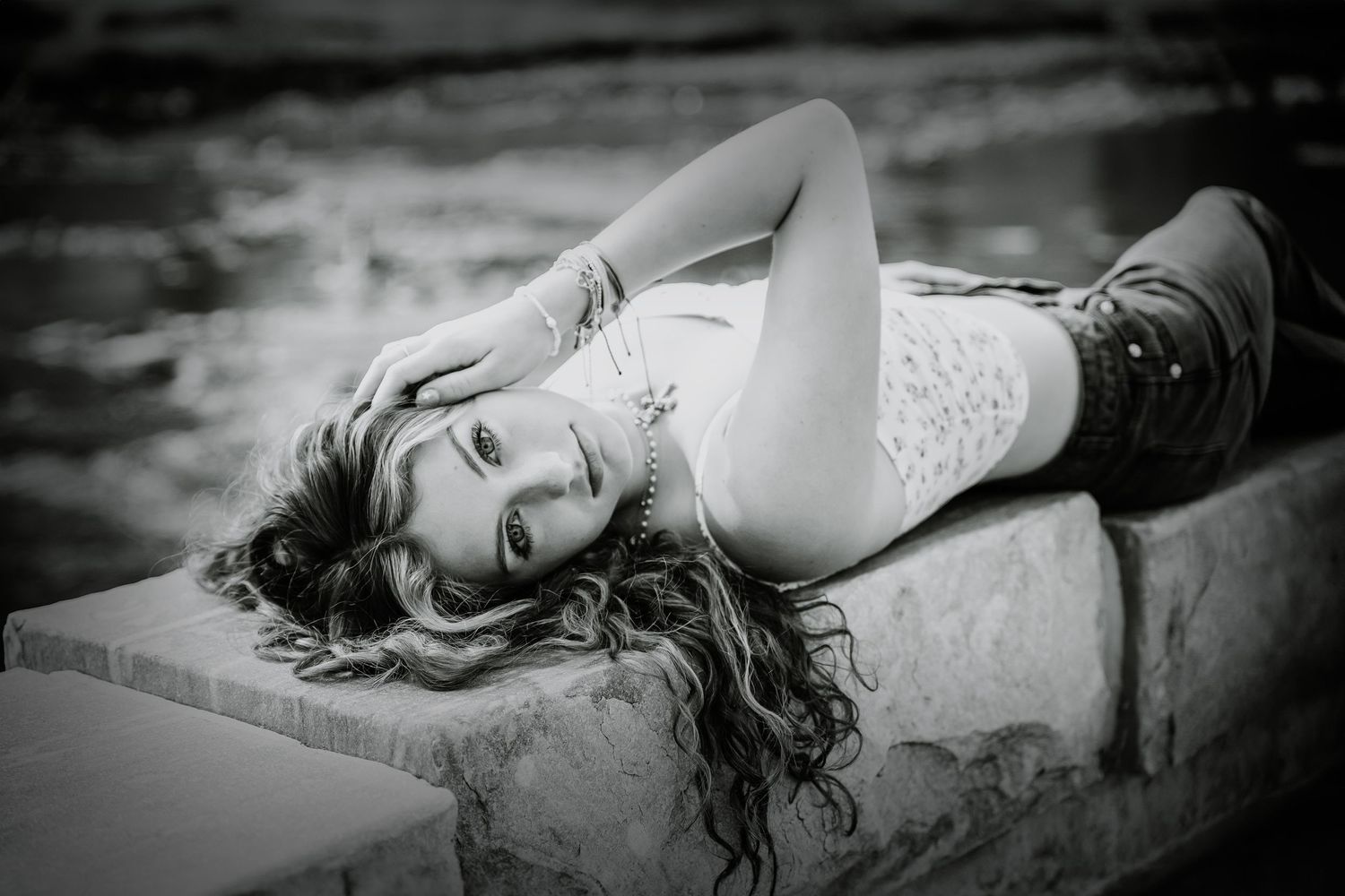 Black and white artistic portrait series with dramatic poses on textured ground.