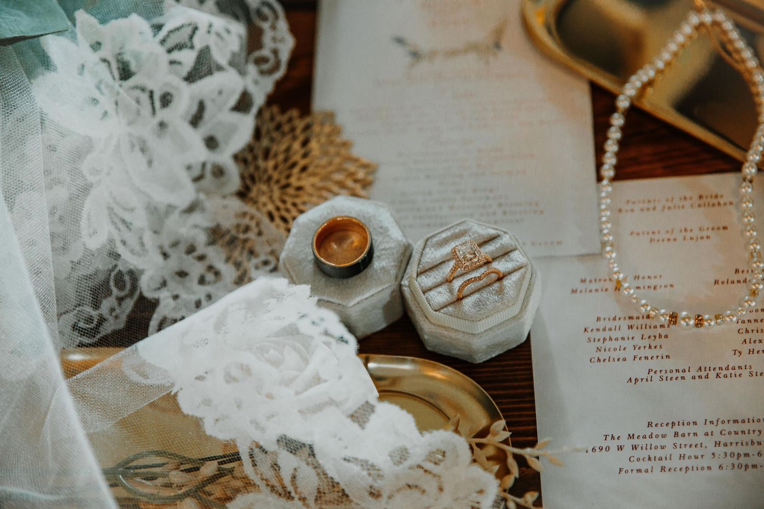 Wedding invitation and delicate lace details arranged on wooden surface. Photographer in Sioux Falls, SD