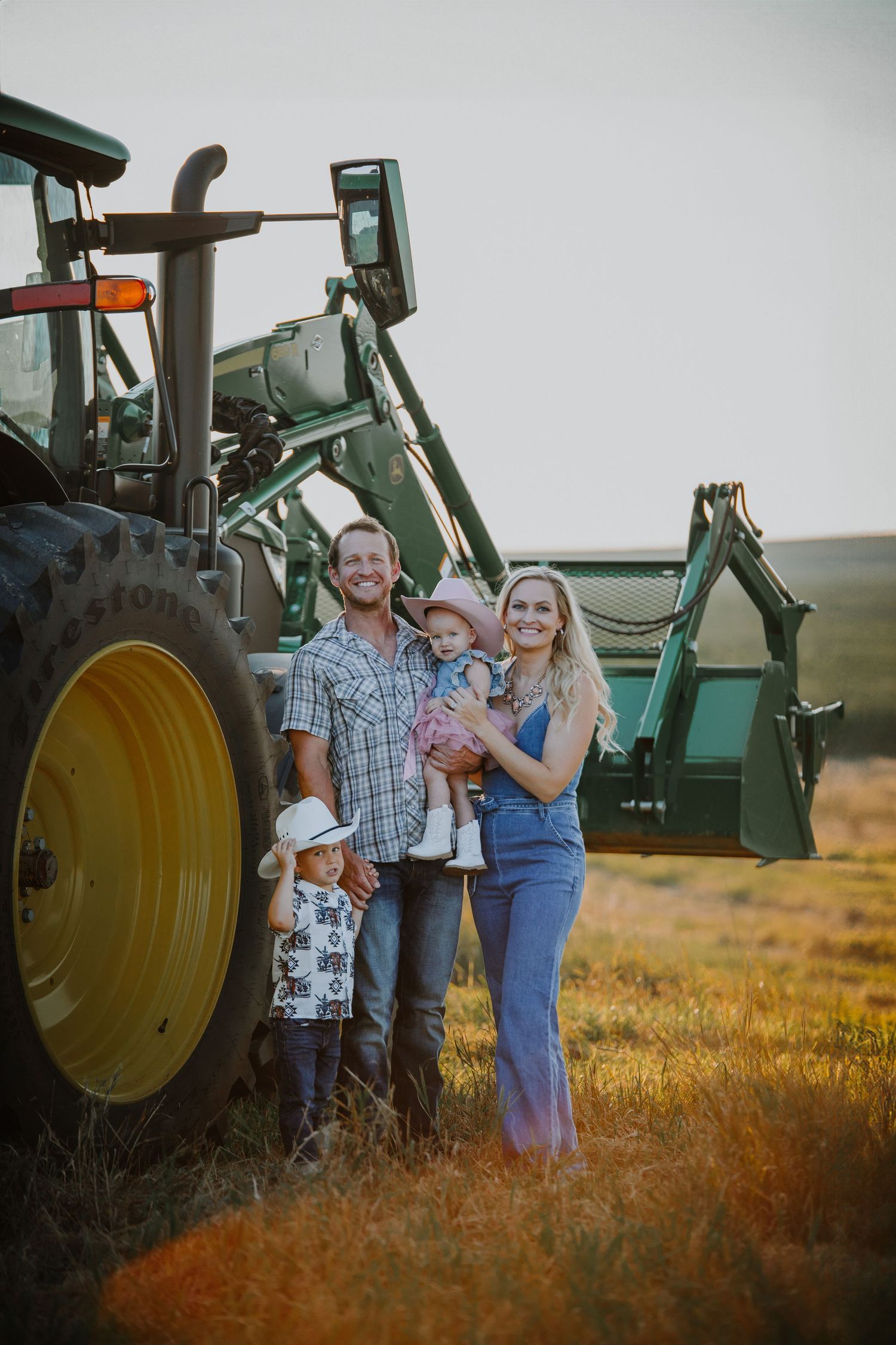 Farm family photo session with John Deere tractors in the golden sunset light.