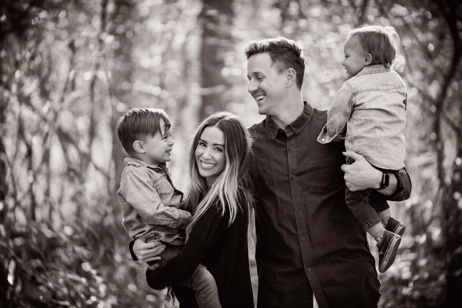 Candid family moment captured in black and white outdoors.