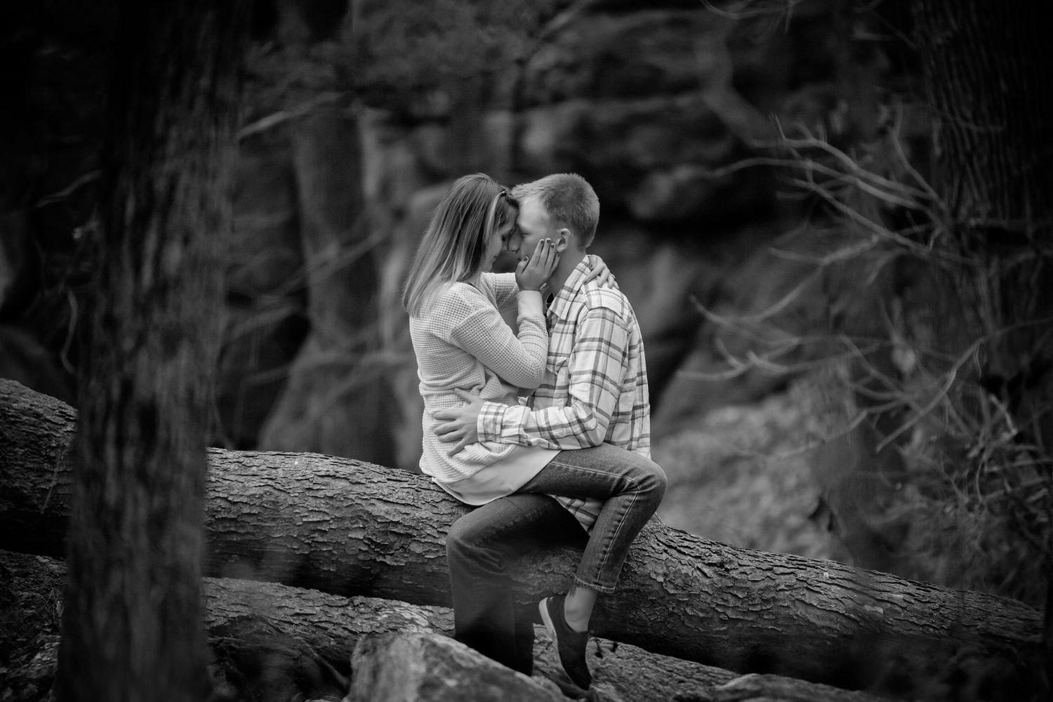 Intimate engagement photos taken in wooded setting with dramatic lighting. Photographer in Sioux Falls, SD