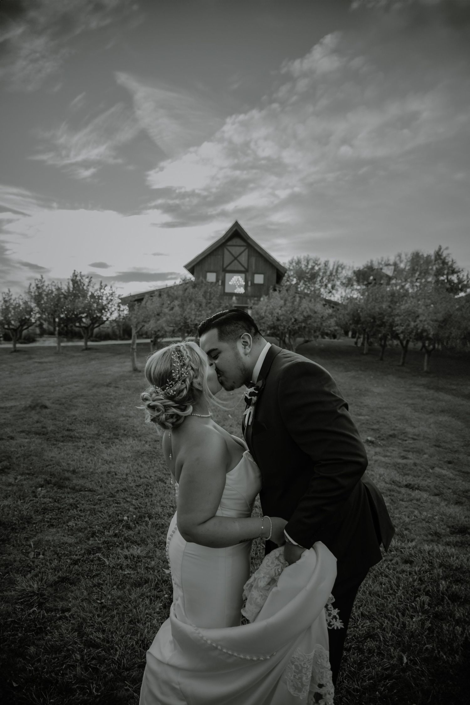 Black and white wedding portraits in rustic outdoor setting with gazebo in background.