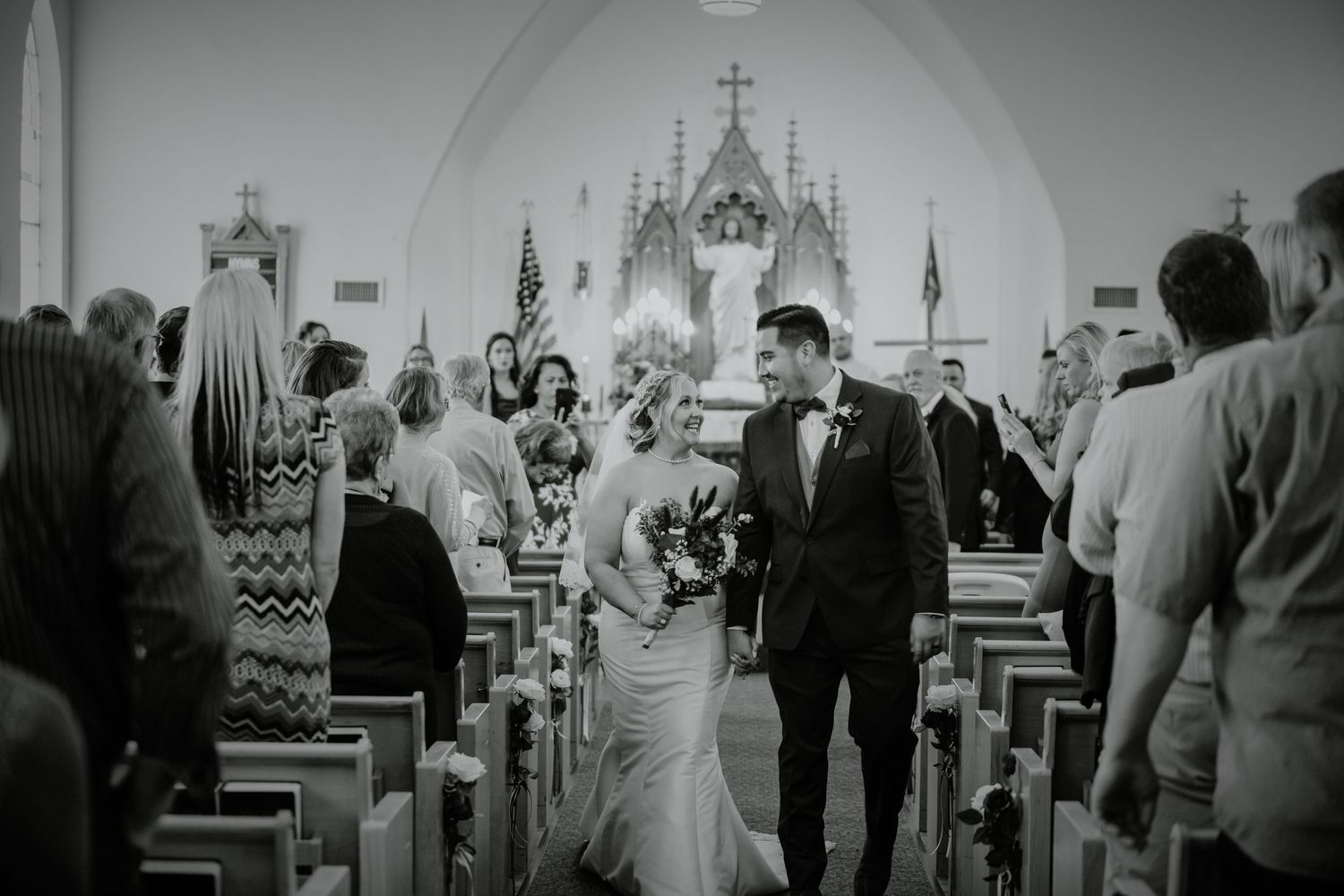 Black and white image of wedding ceremony in traditional church setting.