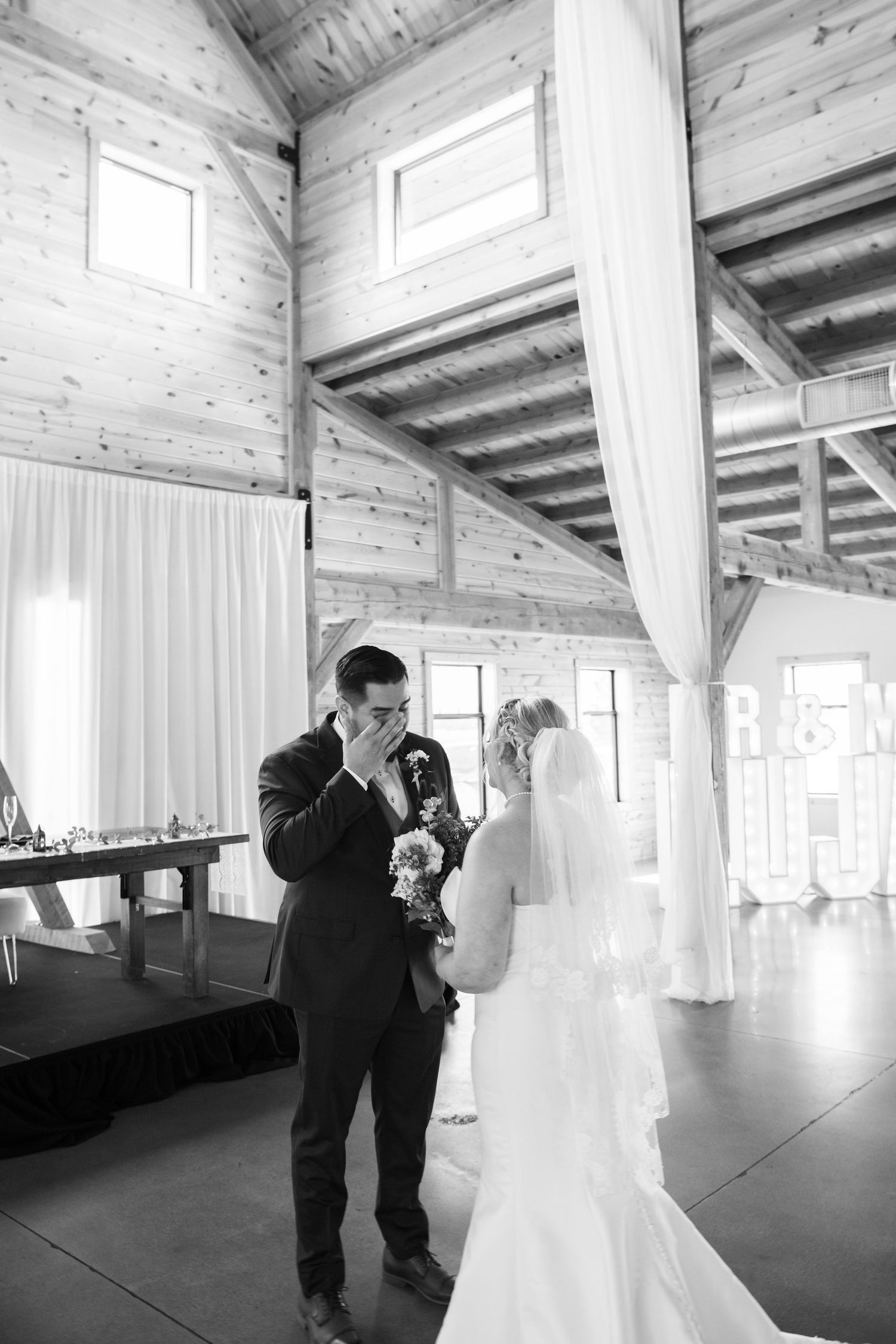 Wedding couple's first look in a light-filled rustic barn venue.