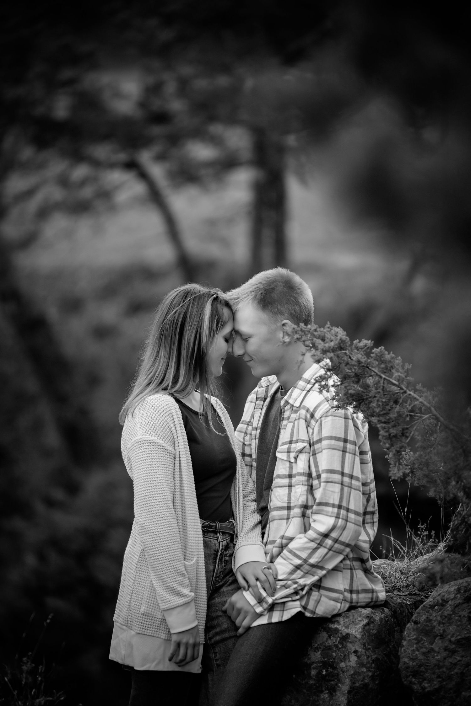 Black and white portrait of couple sharing intimate moment against natural outdoor background. Photographer in Sioux Falls, SD