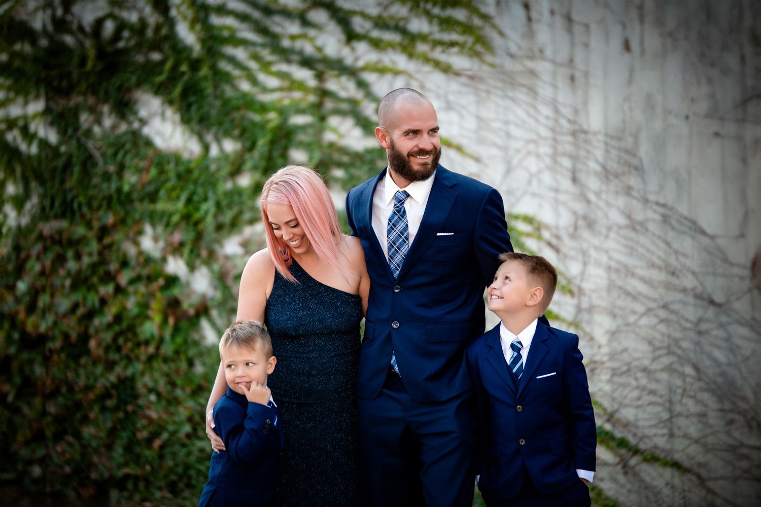 A series of candid outdoor wedding photos showing sweet emotional moments between couples against a gray wall backdrop.
