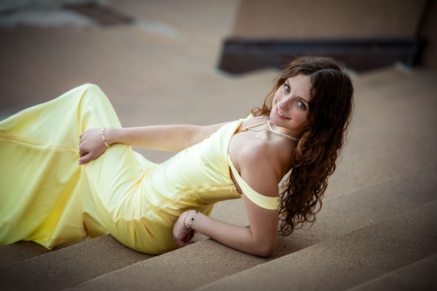 A sequence of artistic boudoir photos showing a woman in a yellow dress reclining on a beige carpet.