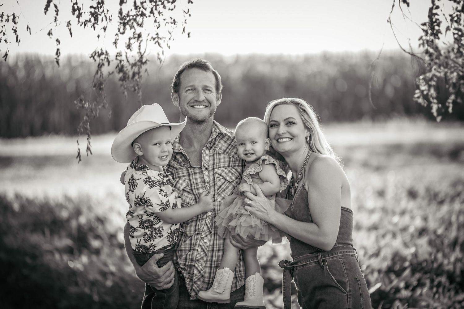 Family portrait series set in a sun-lit field with vintage style editing.
