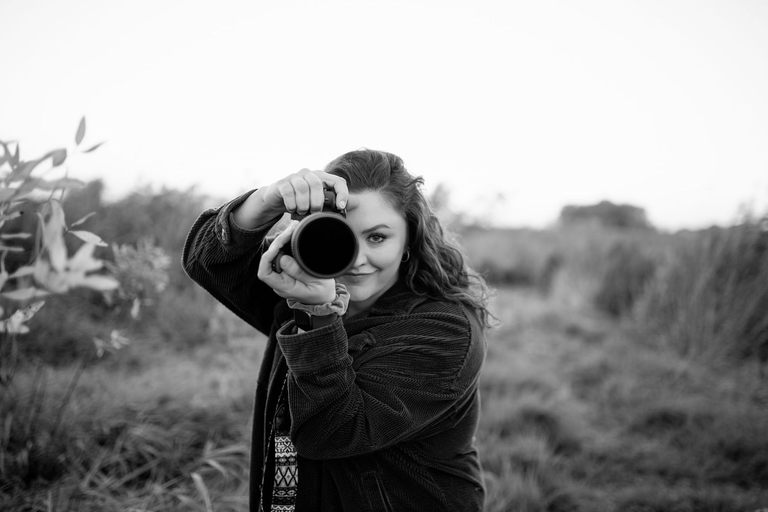 A series of five black and white photographs showing a photographer taking pictures outdoors.