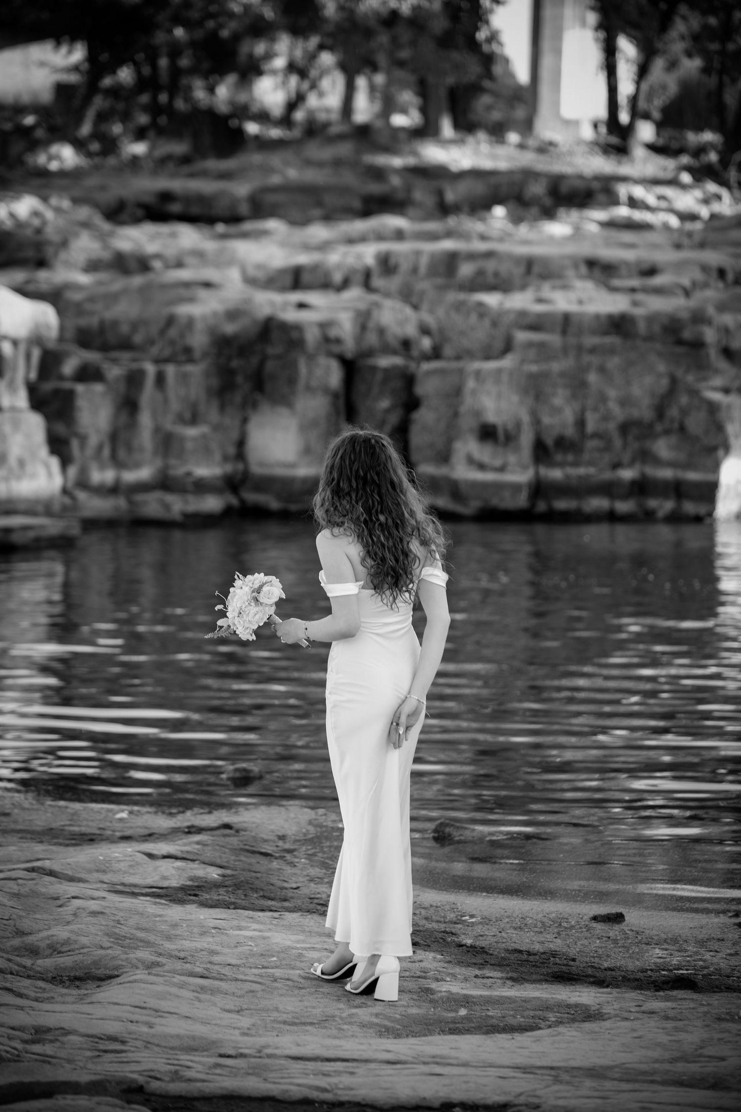 A black and white photo sequence shows a person in white standing by a tranquil pond with rocky edges.