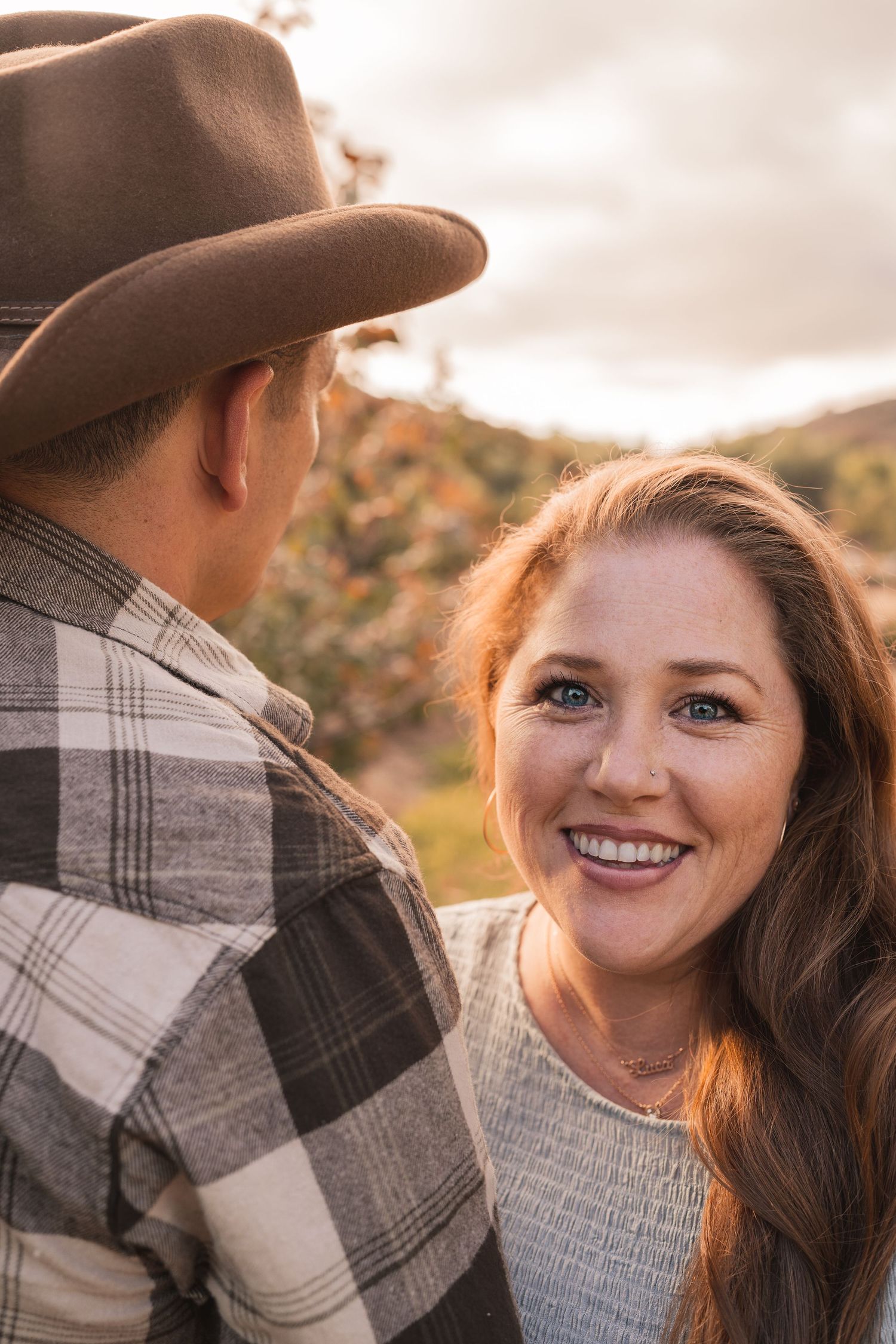 Romantic sunset portrait session in natural outdoor setting with warm lighting.