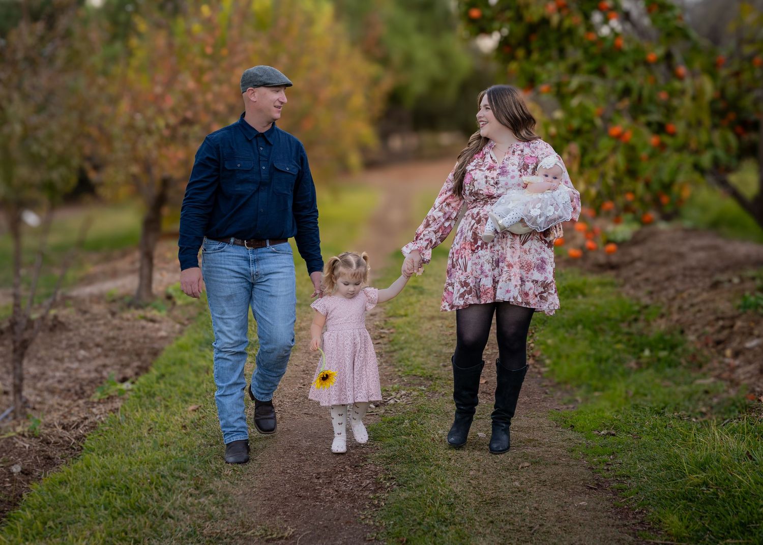 Family walking together along scenic nature trail during photo session.