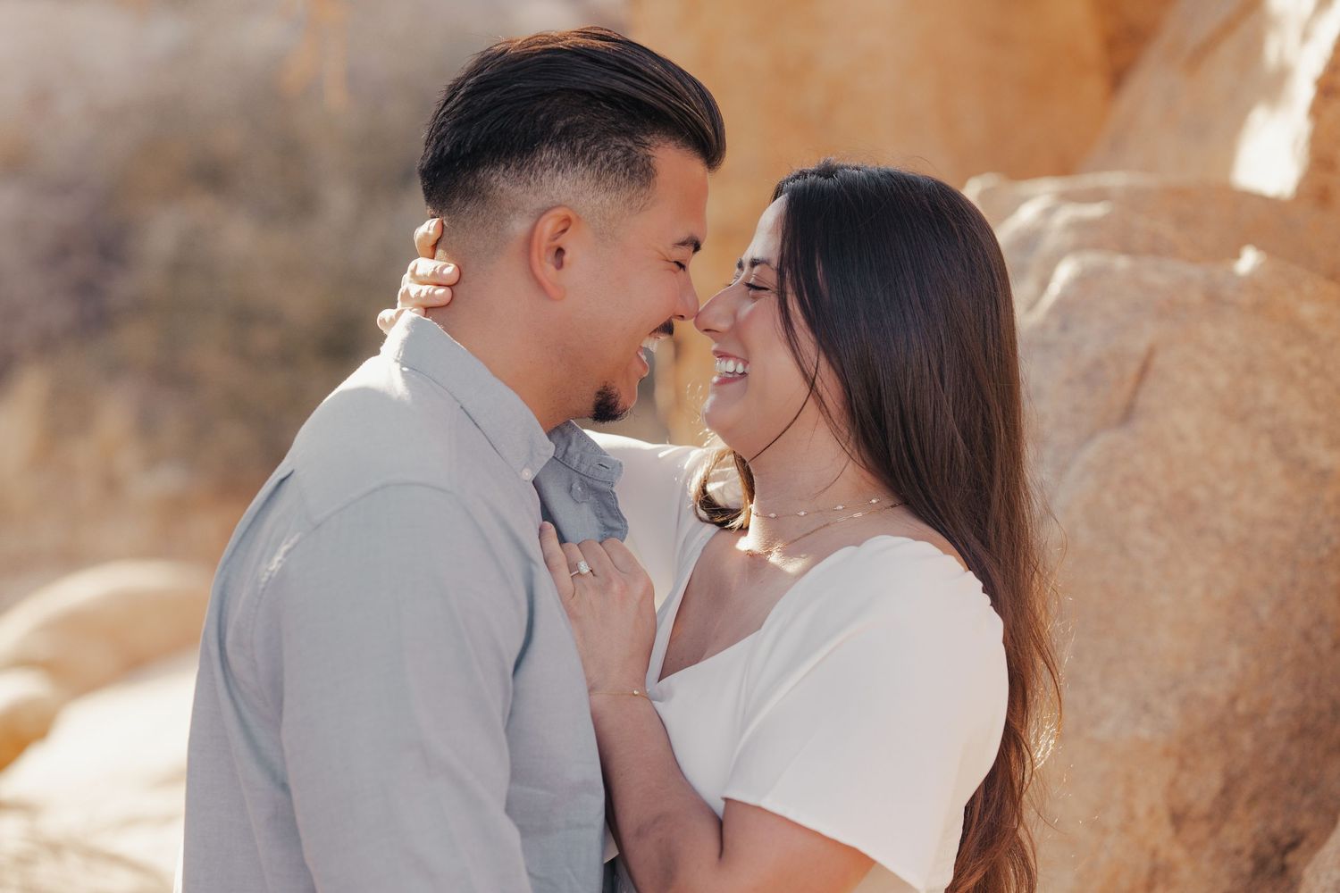 An intimate moment between a couple against desert rock formations.