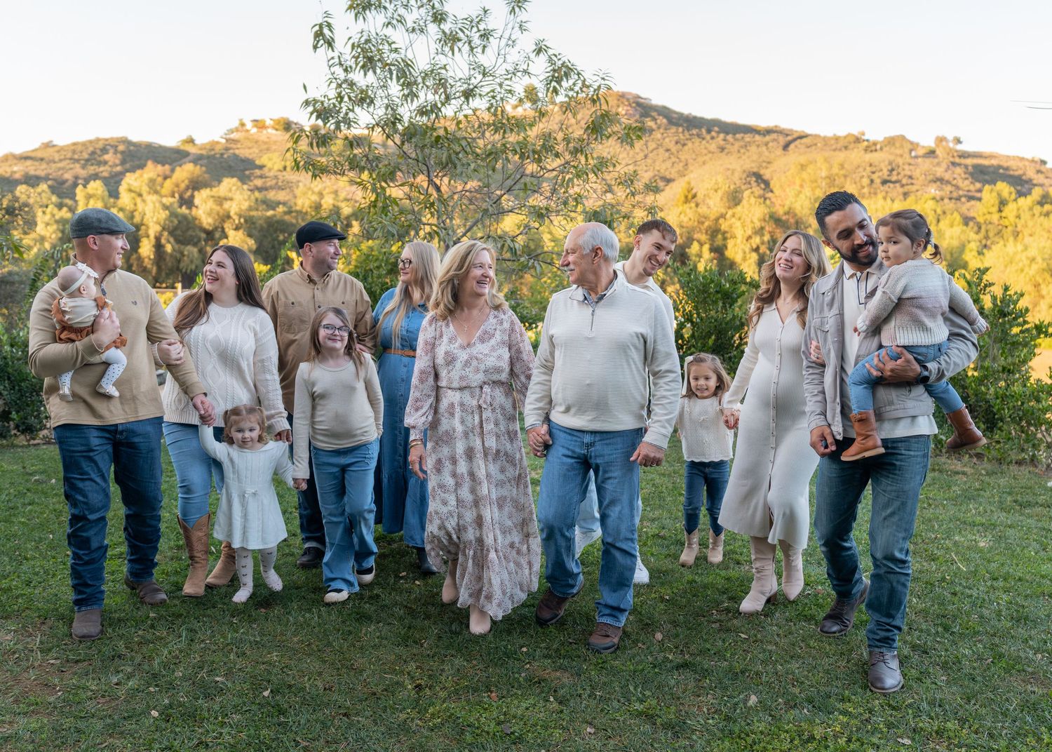Extended family gathering for outdoor portraits against a scenic mountain backdrop.