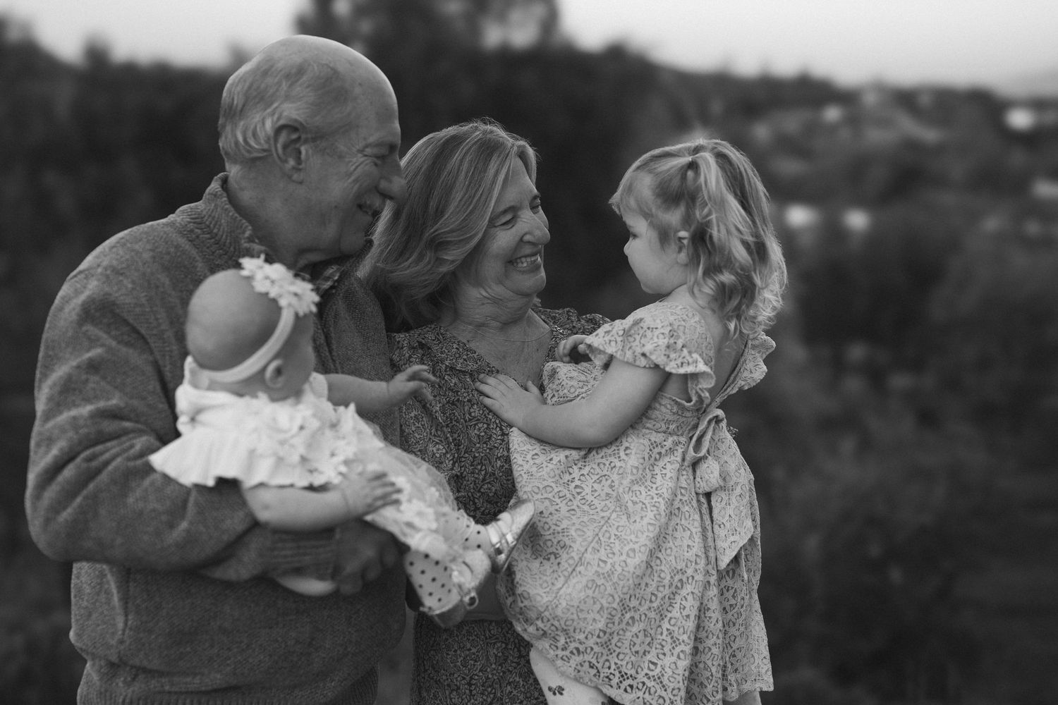 Black and white portrait series capturing intimate family moments with grandparents outdoors.