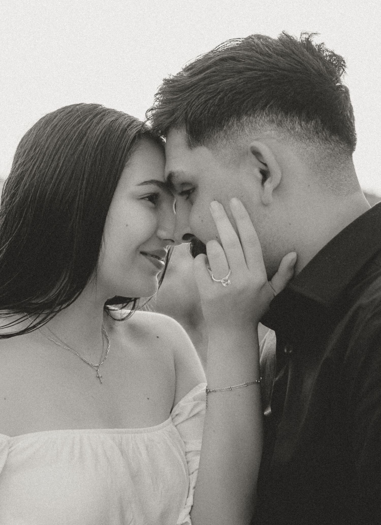 Intimate black and white portrait of couple sharing tender moment.