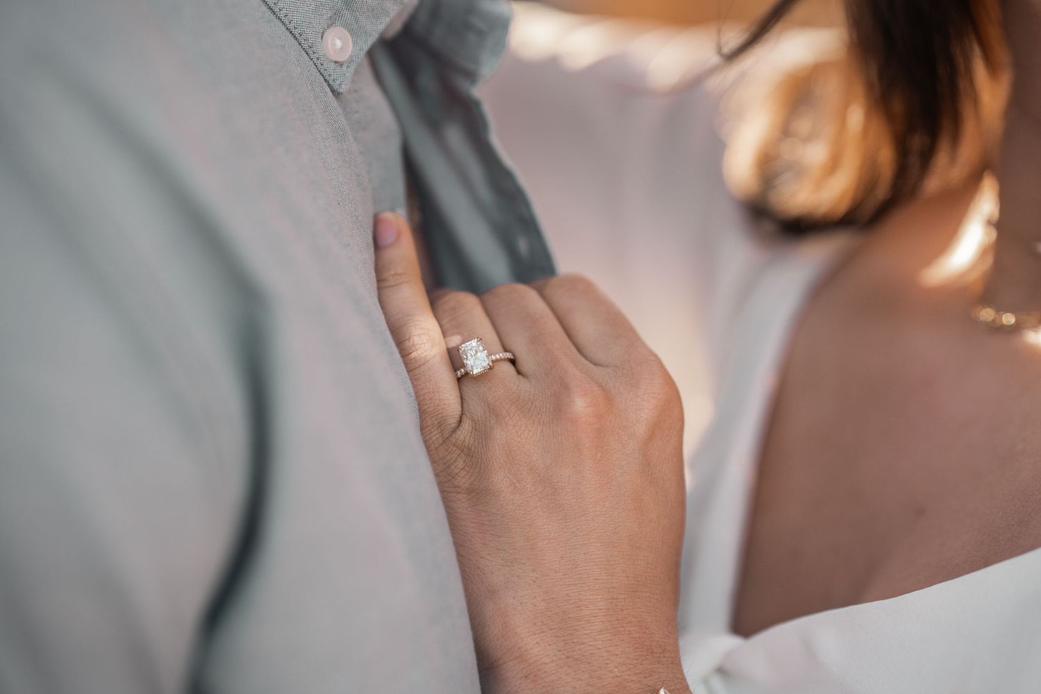 Close-up shot of hands showing an engagement ring.