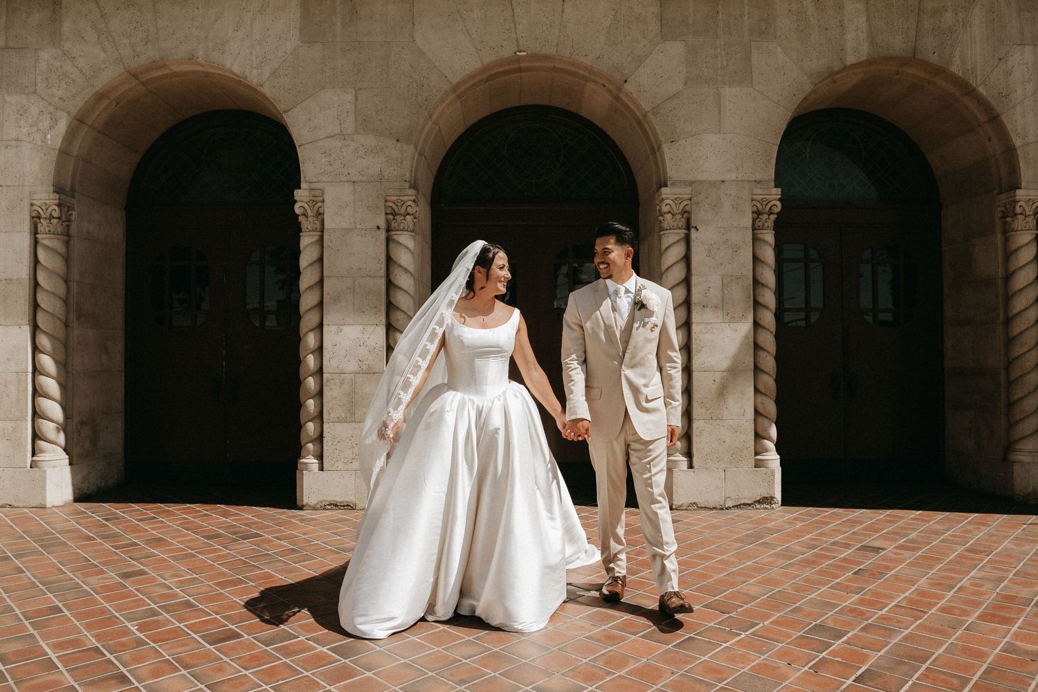 A series of five wedding photos showing a couple sitting on stone steps in formal attire at a historic venue.