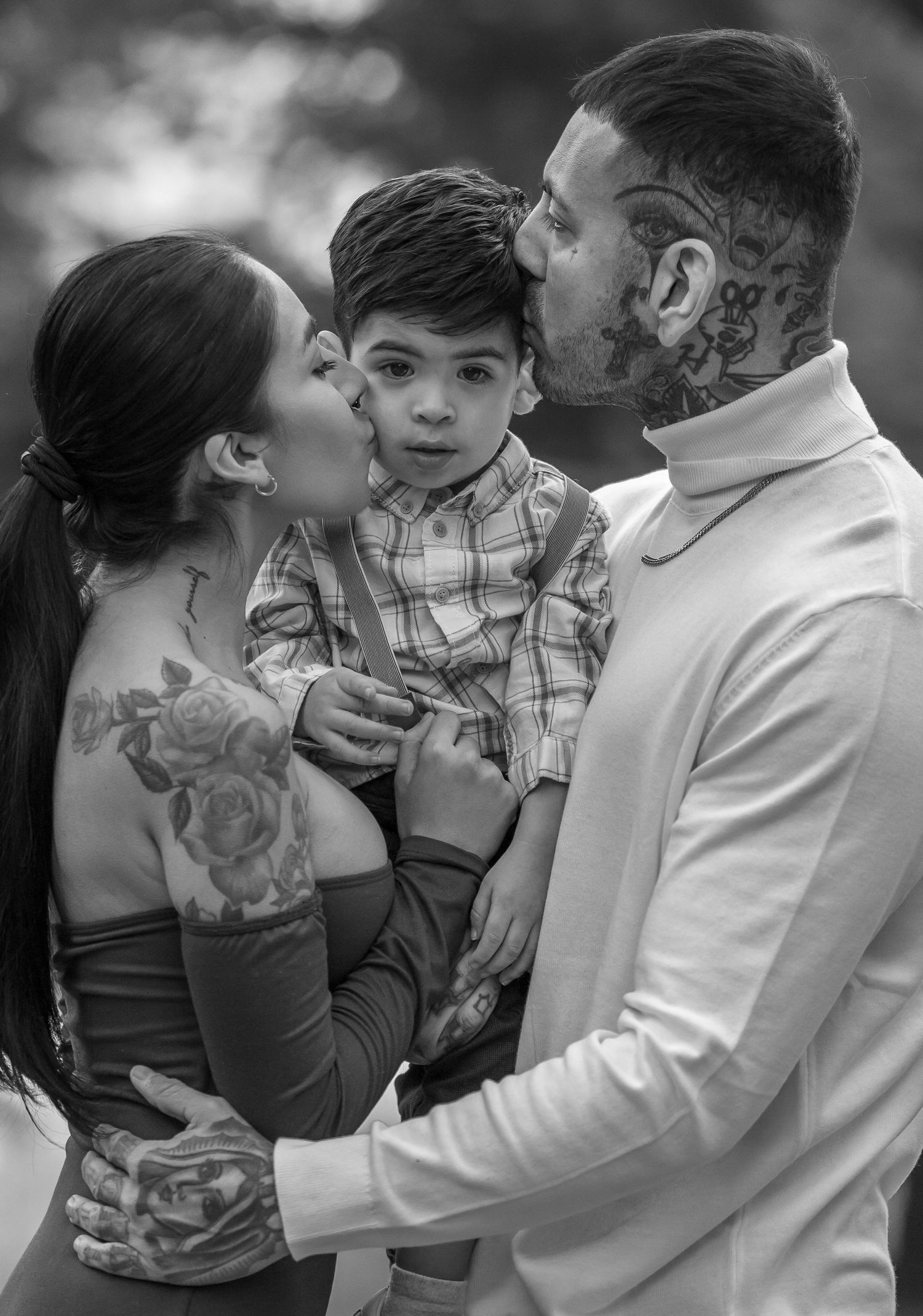 Black and white family portrait showing tender embraces outdoors.