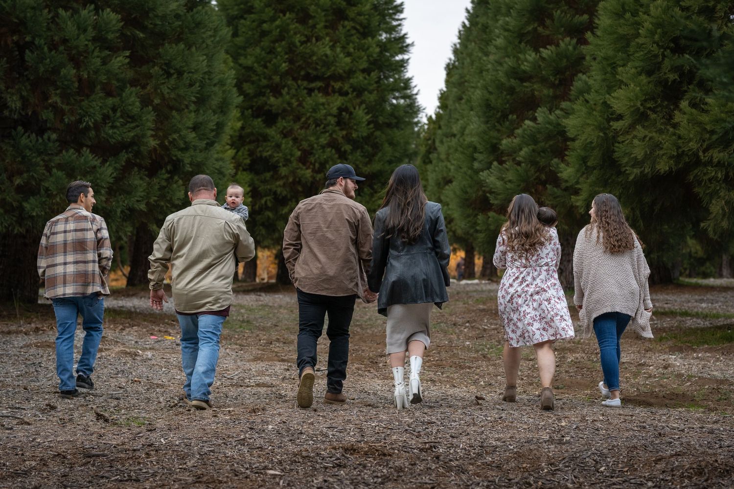 Group of people walking together on a tree-lined path.